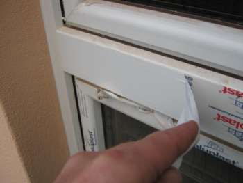 Schutzfolie wird nach dem Verputzen vom neuen Fensterrahmen abgezogen