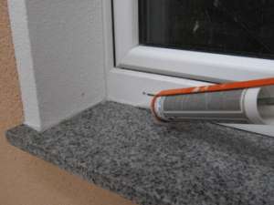 Silikon satt in die Ecke zwischen Fensterbank und Laibung einbringen